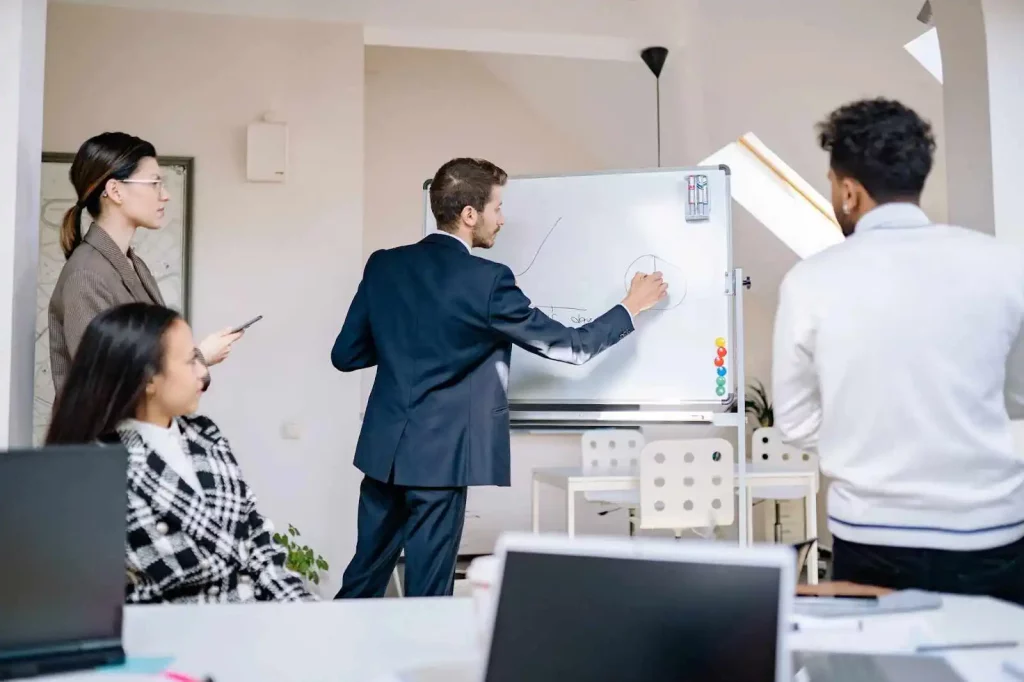 people in the office are writing something on a white board