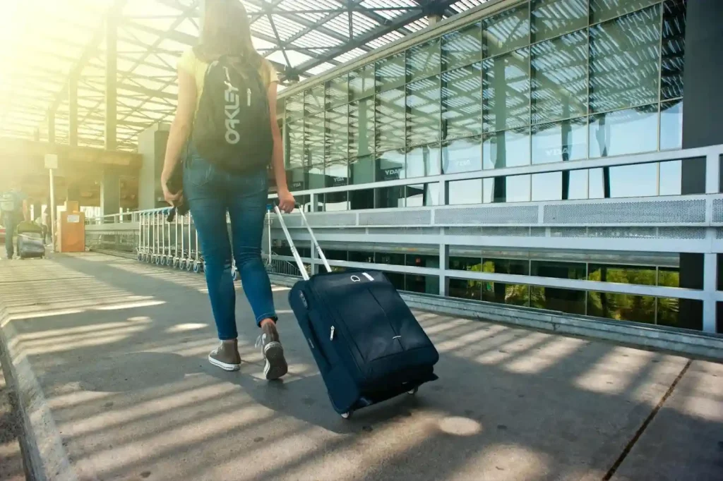a woman carries luggage for domestic airplane travel