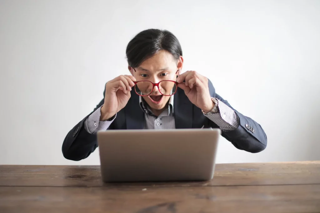 seorang pengusaha sedang memantau kinerja bisnisnya melalui laptop